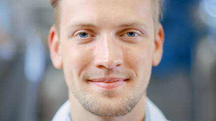 Close Up of a Handsome Young Blond Male Portrait Shot. He's a Professional Employee. Man Looks and Smiles at Camera. Expresses Success and Happiness. He Has Blue Eyes and Light Beard.