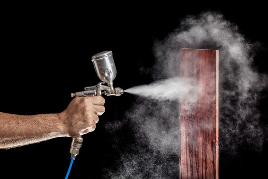Close up of a spray paint gun with brown background