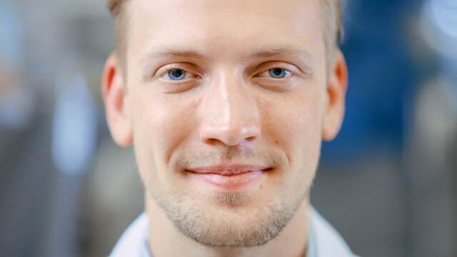 Close Up Of A Handsome Young Blond Male Portrait Shot. He's A Professional Employee. Man Looks And Smiles At Camera. Expresses Success And Happiness. He Has Blue Eyes And Light Beard.