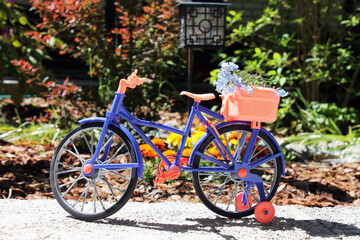 Fototapeta na wymiar toy bike near a flower bed