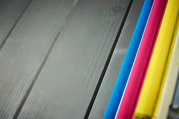 Set of rollers in color laser printer ink cartridges on wooden background