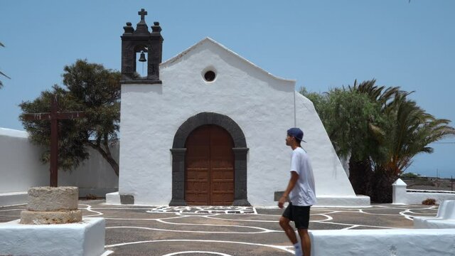 Hombre joven intenta abrir la puerta de una peque&ntilde;a iglesia solitaria en El Mojon. Lanzarote
