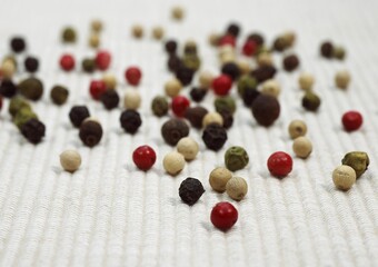 FIVE PEPPERCORNS AGAINST WHITE BACKGROUND