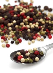 FIVE PEPPERCORNS AGAINST WHITE BACKGROUND
