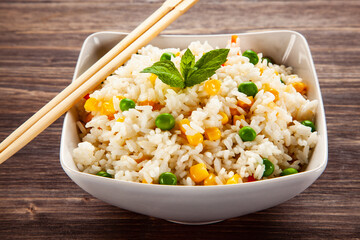 White rice with vegetables on wooden table