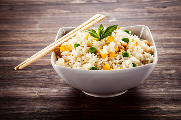 White rice with vegetables on wooden table