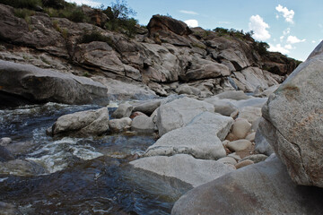 The rapids. River flowing along the rocky cliffs and mountains in a summer sunny day.	
