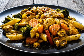 Chicken ragout with penne on wooden table
