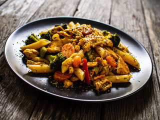Chicken ragout with penne on wooden table
