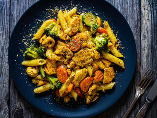 Chicken ragout with penne on wooden table
