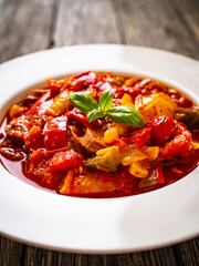 Delicious stew - vegetable with sausages on wooden table