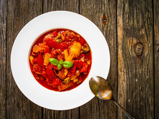 Delicious stew - vegetable with sausages on wooden table
