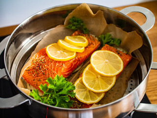 Raw salmon steaks with lemon and parsley in pot
