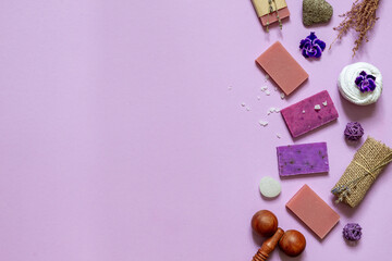 Layout of eco soap with natural ingredients in a purple range. Top view on a lilac background with space