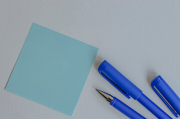 blue pens for writing and blue sticker on white background copy space