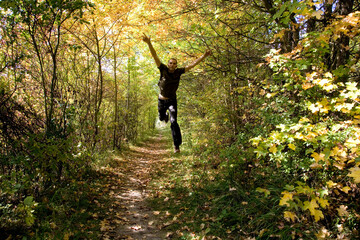 Mann springt im Herbstwald
