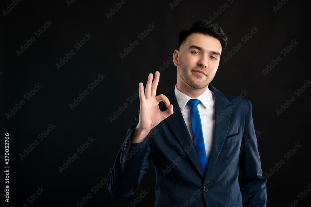 Wall mural portrait of business man wearing blue business suit and tie showing ok gesture