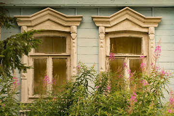 Obraz premium old wooden windows with beautiful carved platbands