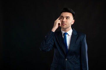 Portrait of business man wearing blue business suit and tie making thinking gesture