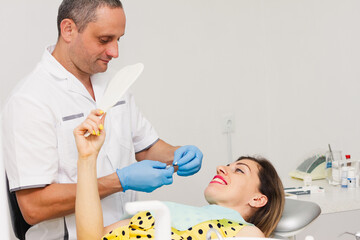 Male dentist treating a woman's teeth.