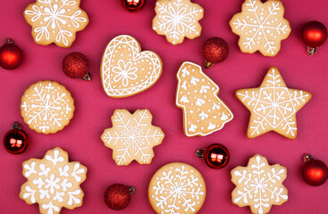 gingerbread snowflakes with red Christmas balls on a dark red background with copy space for text