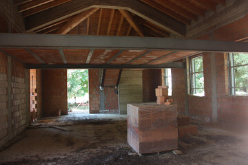 ceiling of a house under construction with red brick and exposed beams