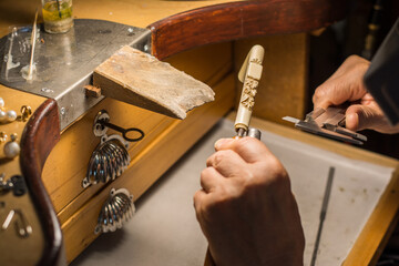 Hands of a craftsman jeweler working on jewelry. Goldsmith.
Goldsmith workshop jewels and articles...