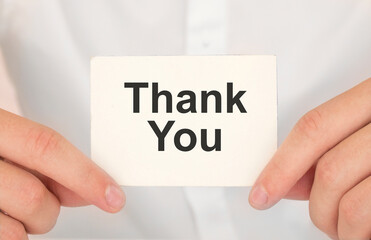 Hand writing Thank You with blue marker on transparent wipe board.