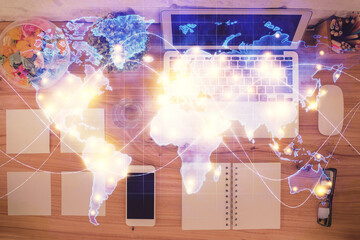 Business theme hologram drawings over computer on the desktop background. Top view. Multi exposure....