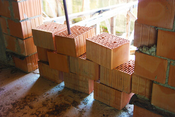 a stack of red bricks to build a house within the structure