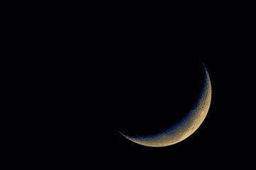 Telescope view of a thin crescent moon