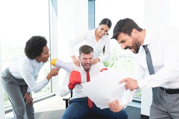 Colleagues motivating man with boxing gloves to achieve his target through fighting spirit