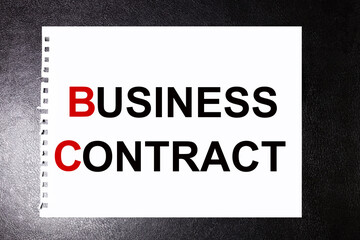 business contract. text on white sheet of paper on black background