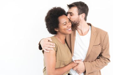 Loving couple embracing and kissing over white background