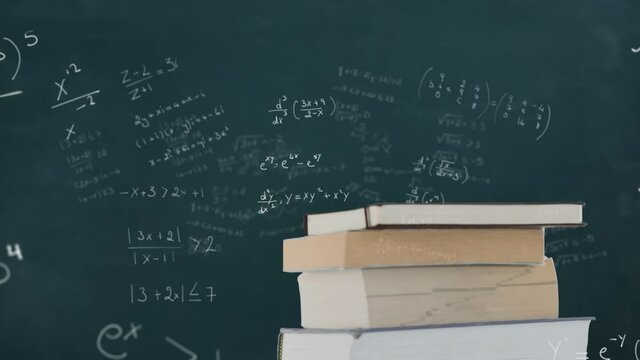 Book against mathematical equations on black board