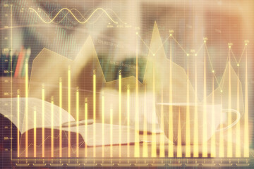 Multi exposure of forex graph drawing and desktop with coffee and items on table background. Concept of financial market trading