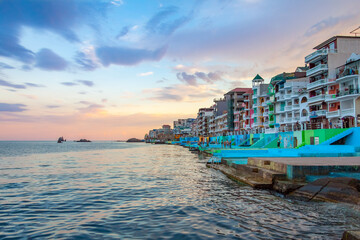 Embankment in the Utes city, Crimea in at sunset. Colorful houses are close to each other,...