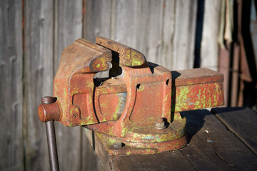 Locksmith tools. Vintage locksmith vise attached to wooden table. Close-up