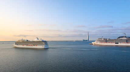 Obraz premium Ships and luxury liners sail and dock at the cruise port of Saint Petersburg, Russia with Europe's tallest skyscraper, the Lakhta center in view on the coast of Gulf of Finland