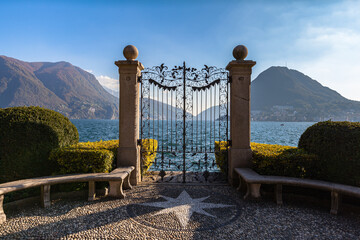 Stunning panorama view of Lugano Lake with Monte San Salvatore in background from gate of Cancello sul Lago di Lugano in Parco Ciani park on sunny autumn day, Canton of Ticino, Switzerland - 370046940