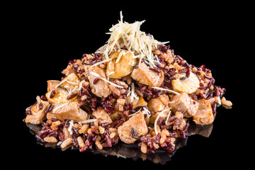 Delicious risotto with pork pieces, mushrooms, sweet sauce and parmesan,  with reflection, isolated on black background