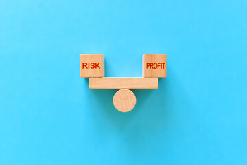 risk profit. wooden blocks with the inscriptions risk and profit on the scales