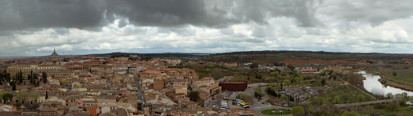 Fototapeta na wymiar Culture and history. Architecture. Cityscape. Panorama view of the town and buildings under a cloudy sky in Toledo, Spain.