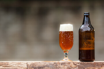 Glass of beer and bottle on wood table