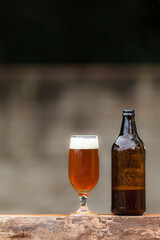 Glass of beer and bottle on wood table