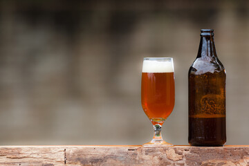 Glass of beer and bottle on wood table