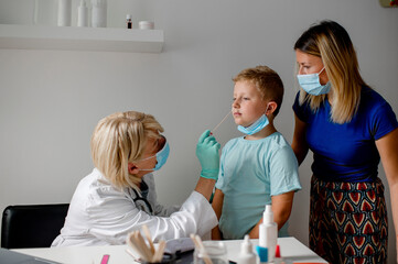 Doctor taking a sample from a boy's nose using a cotton swab