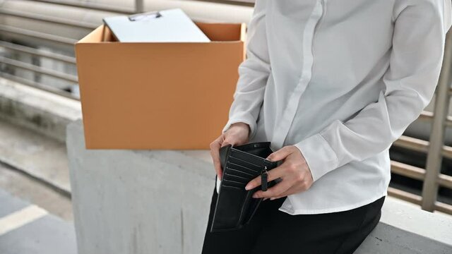 Depressed Asian woman being fired lose the job loooking at wallet without any money due to economic turndown in coronavirus pandemic in the world. 