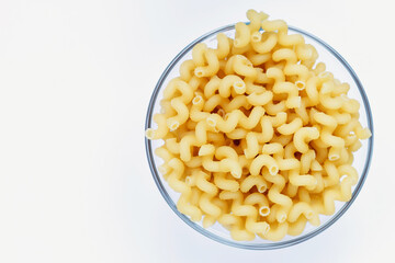Pasta in a glass bowl on a white background. Pasta texture. Durum wheat pasta. Healthy pasta. Vegetarian food.