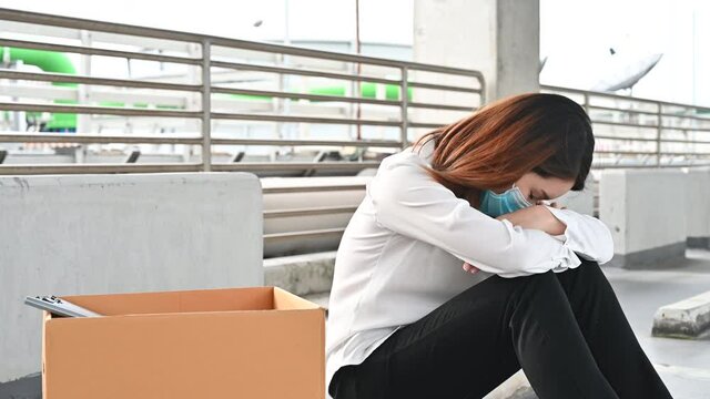 Depressed Asian woman being fired lose the job wearing mask due to economic turndown in coronavirus pandemic in the world. concept of bankruptcy reduction in employment and unemployment
